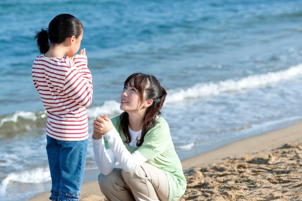 海辺で話す親子