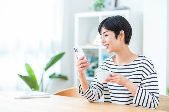 スマホを持ってくつろぐ女性