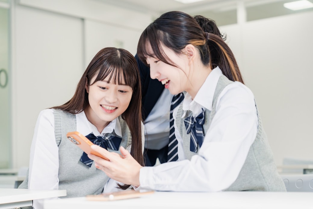 スマホを見る女子高生