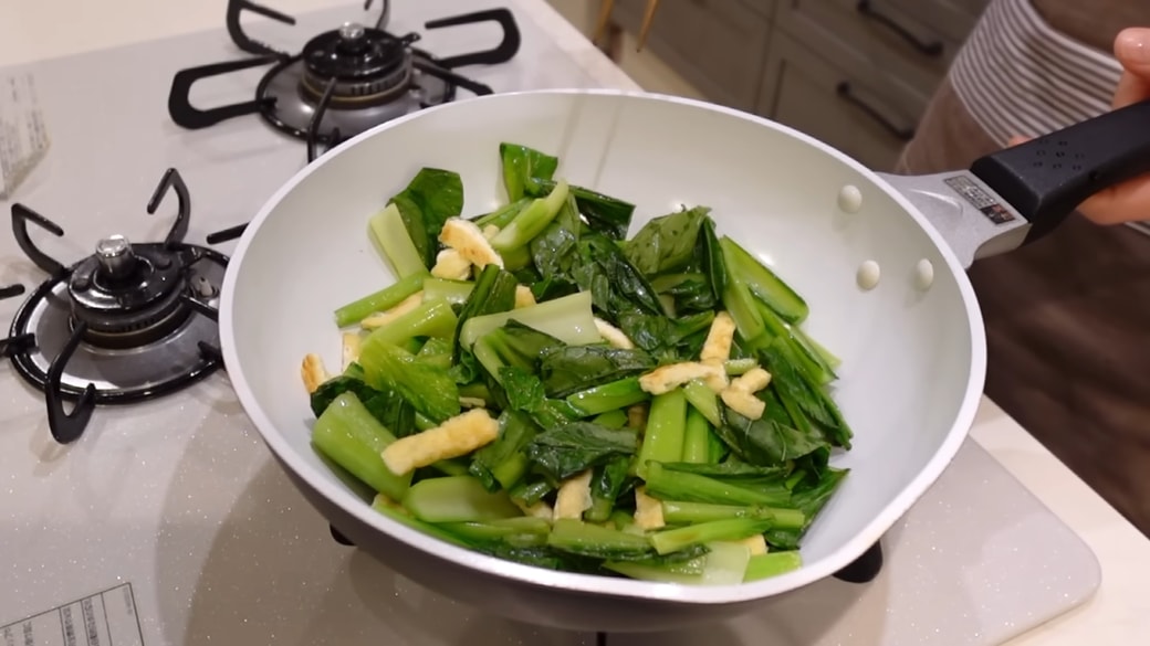 フライパンで油揚げと小松菜を炒める人