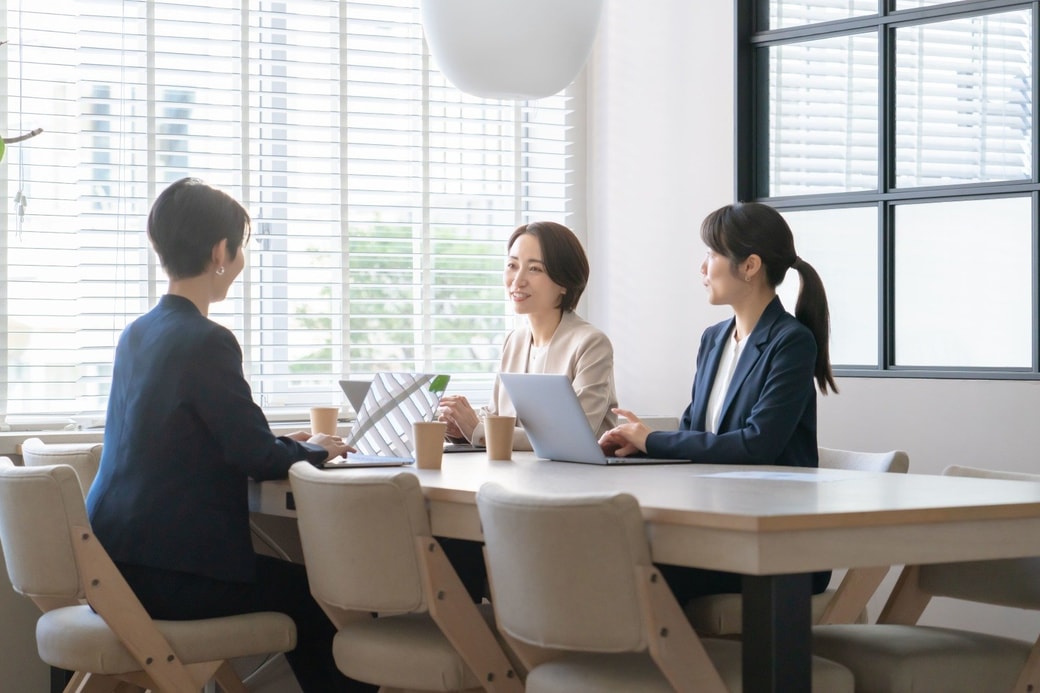 仕事仲間と話す女性