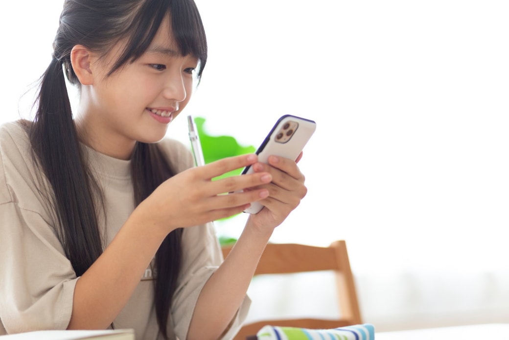 スマホをいじる女子学生
