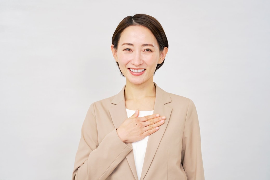 胸に手を当てる女性
