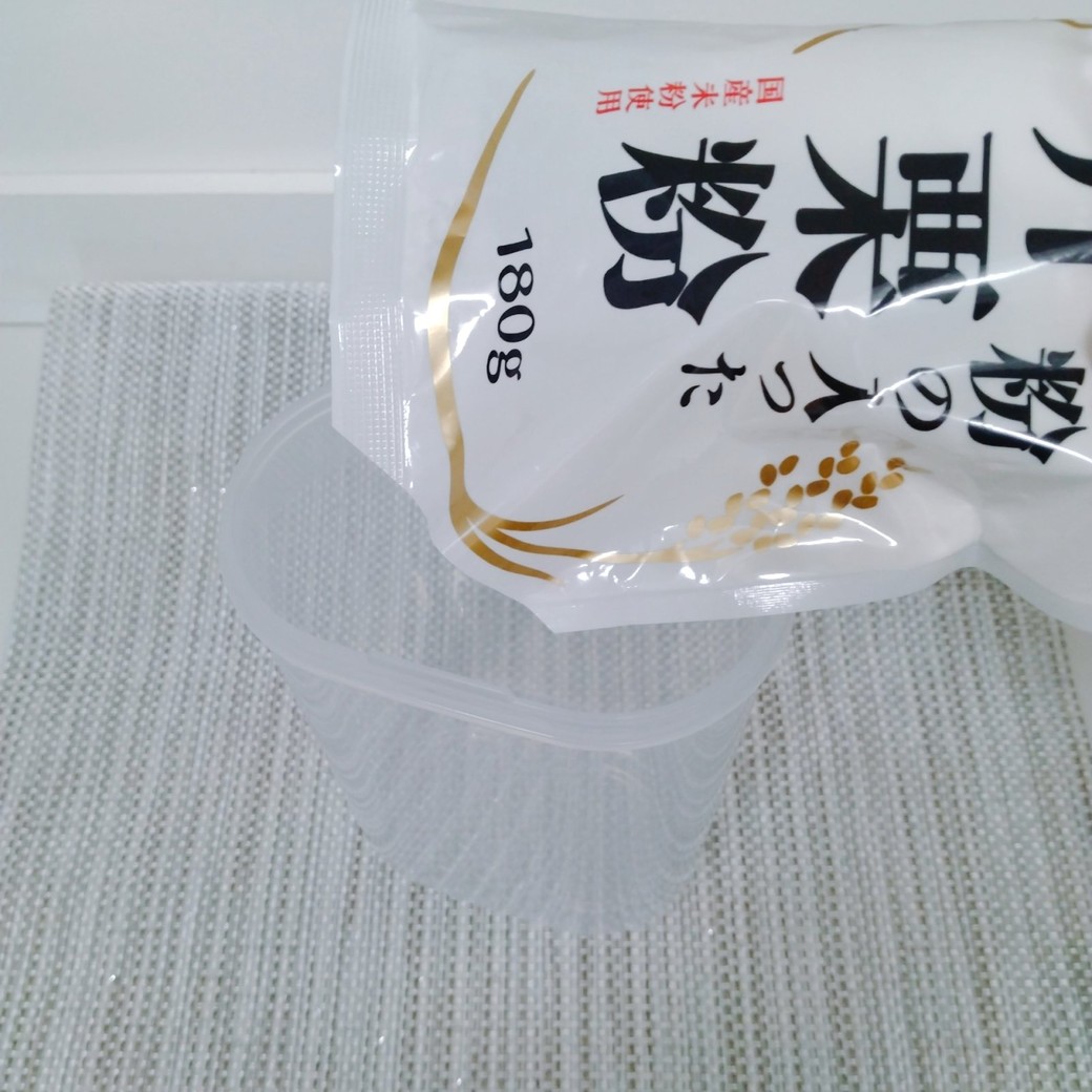 袋に入ったかたくり粉を容器に入れる人