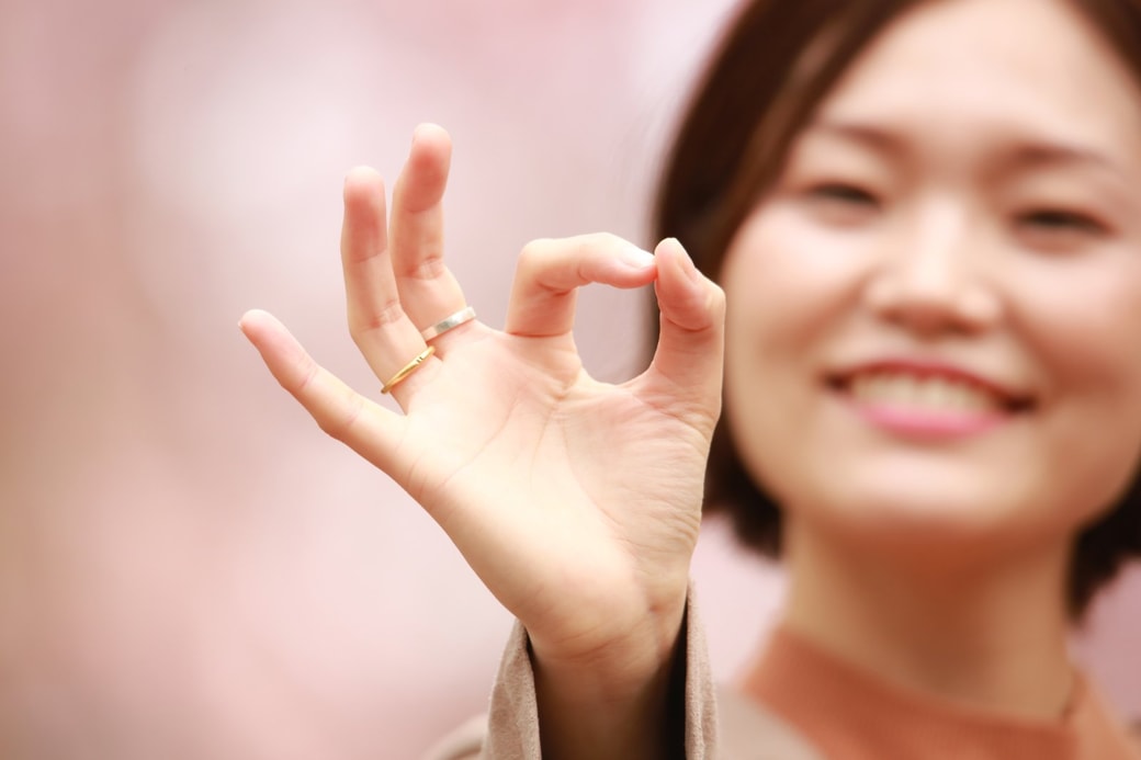 指で丸を作る女性