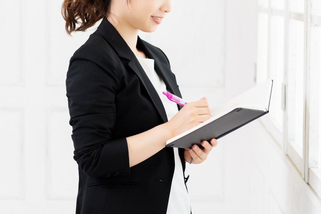 手帳にメモする女性