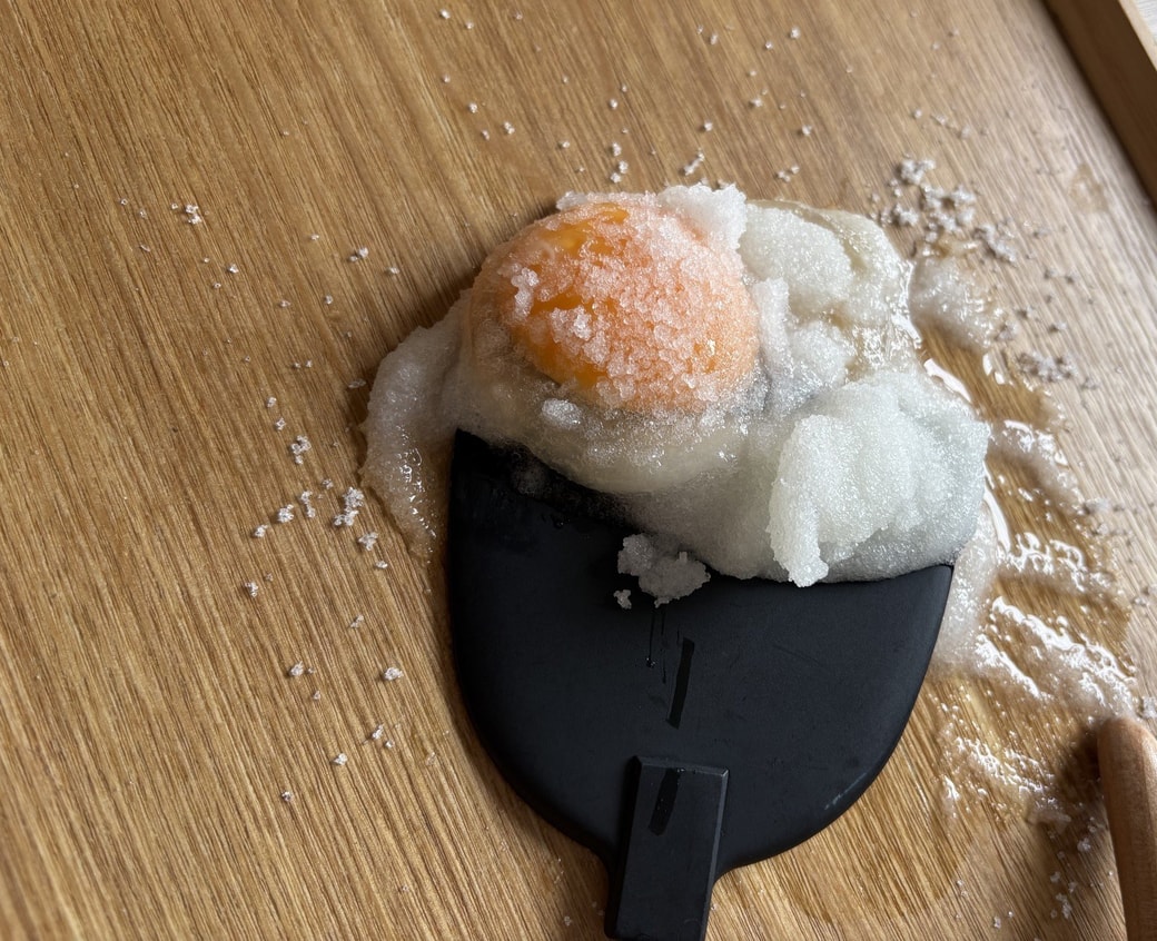 固まった生卵をフライ返しで取り除く様子