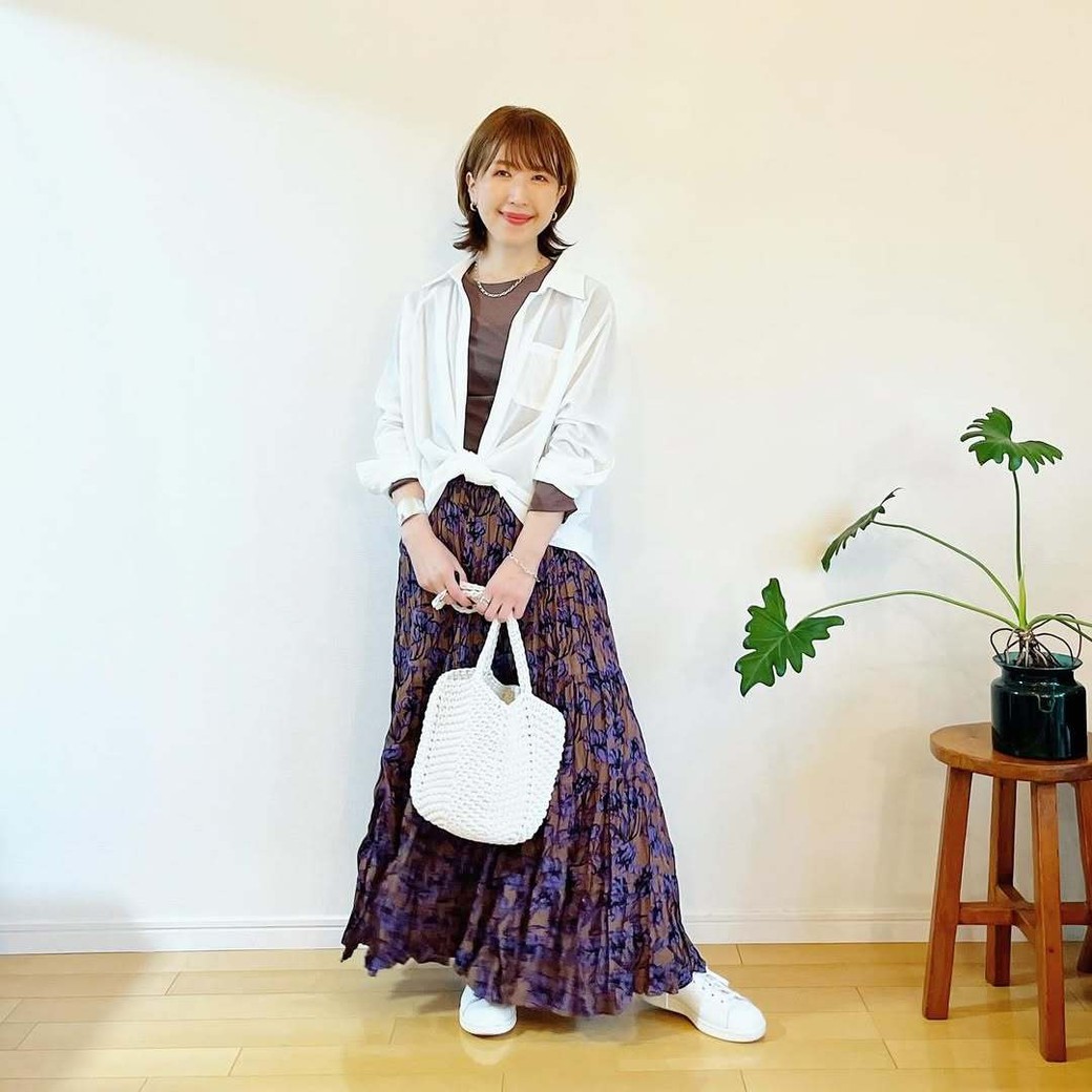 柄が印象的なロングスカートに白シャツでさわやかさをオン。
