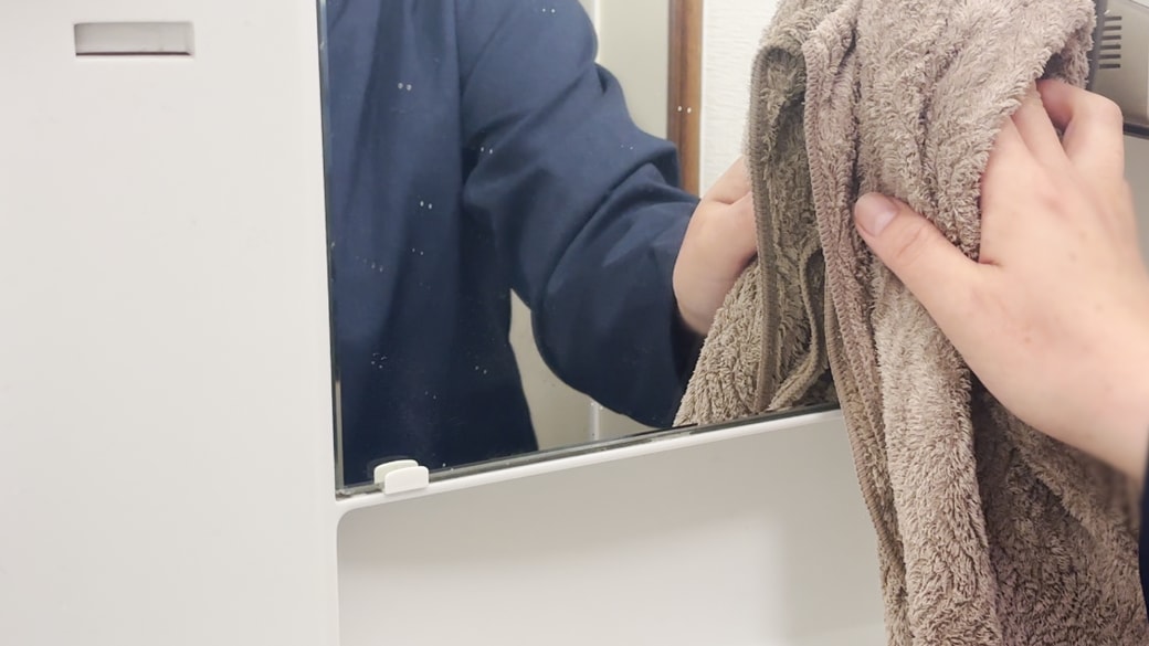 鏡をタオルで拭く