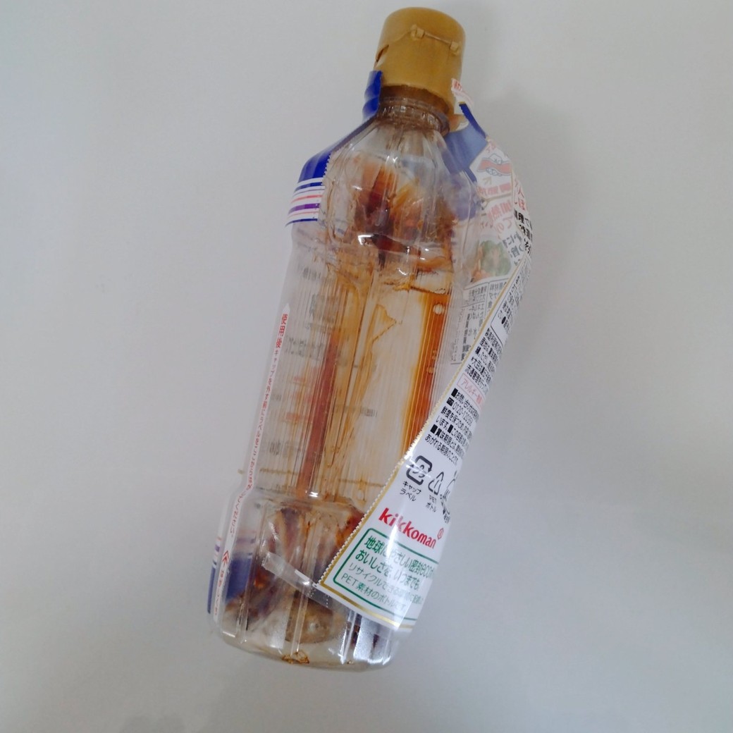 ラベルをはがしている密封ボトルのしょうゆ