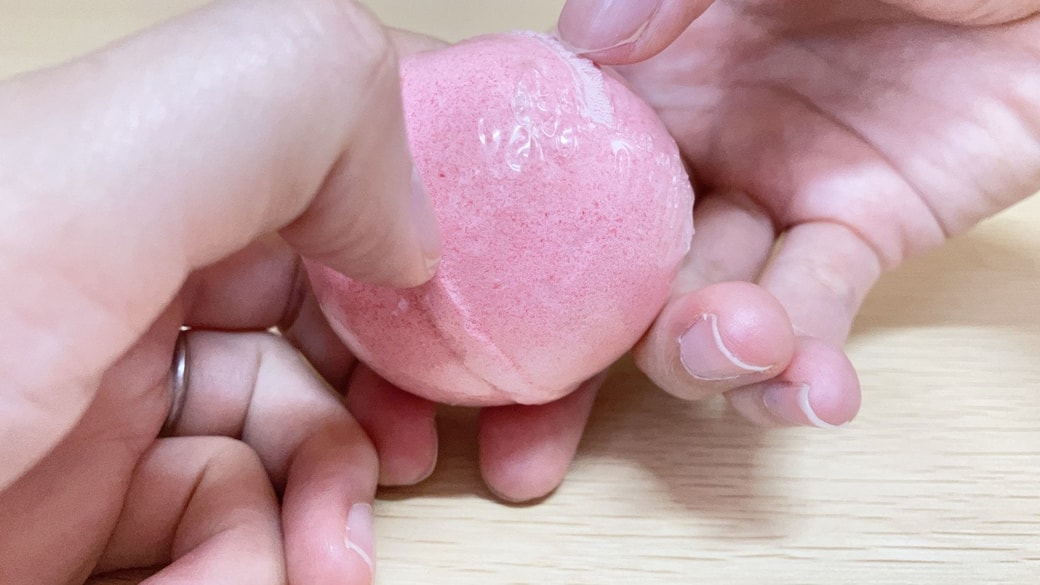バスボムのビニールをはがそうとしている様子