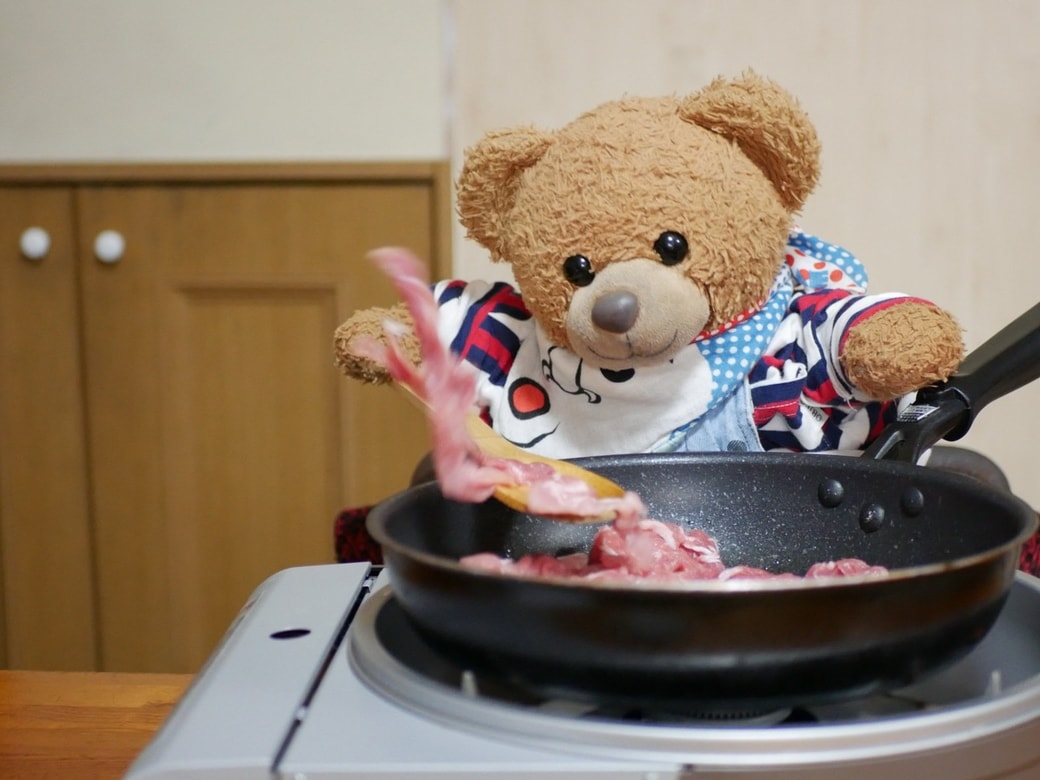 豚肉を炒めるくまくん