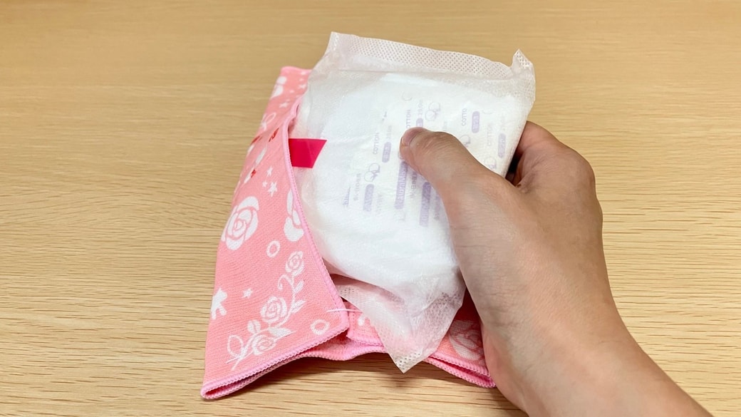 タオルハンカチに大き目の生理用品を入れる様子