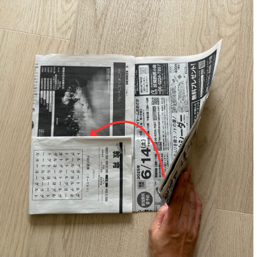 新聞のポケットに片方の新聞を入れる様子