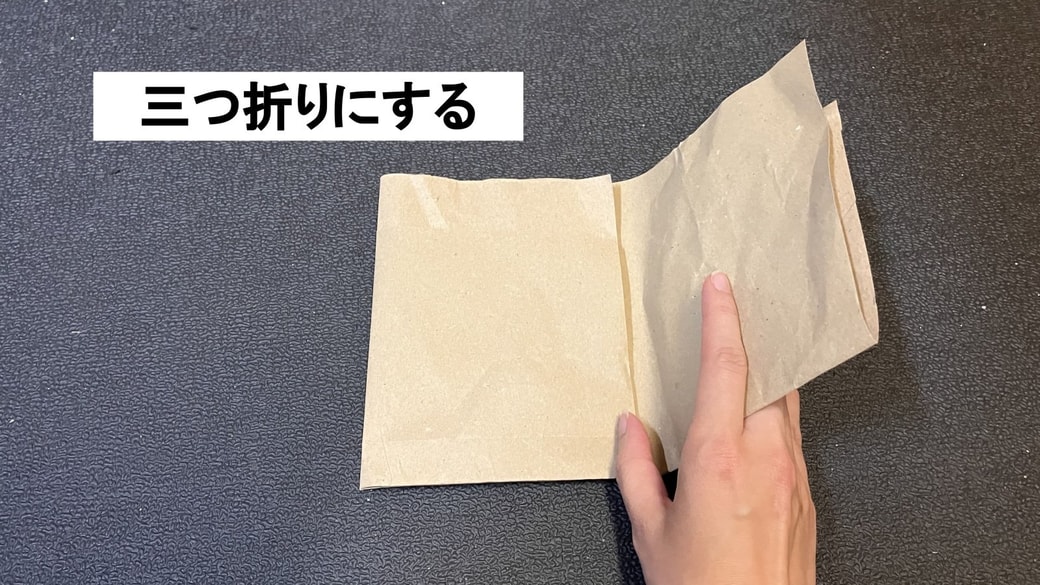 紙の緩衝材を三つ折りにする様子