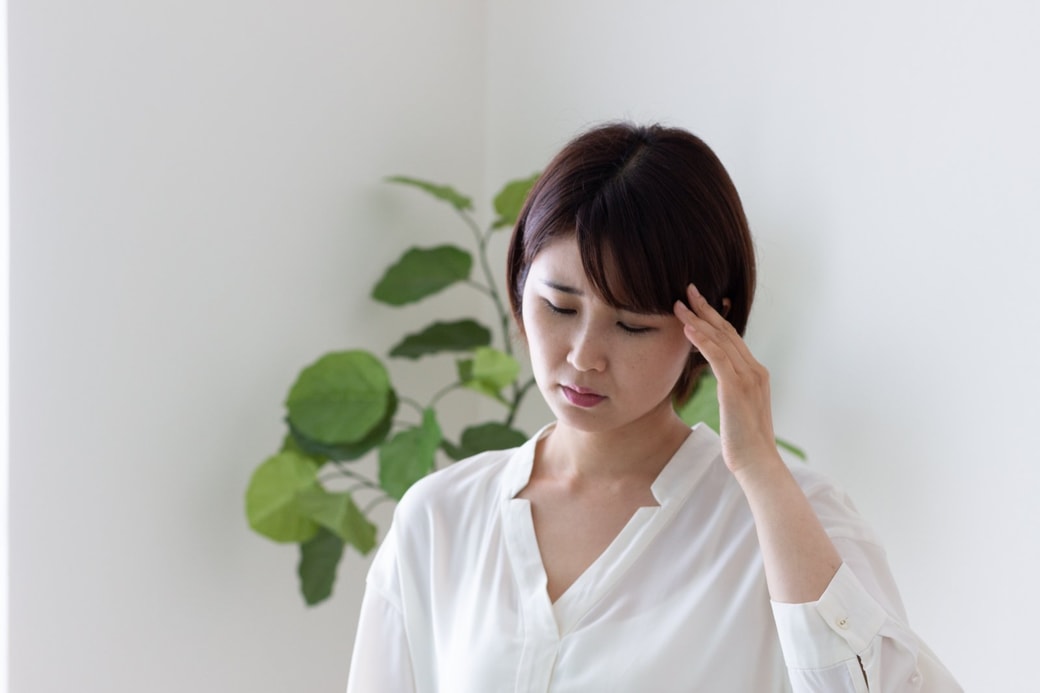 頭を押さえる女性