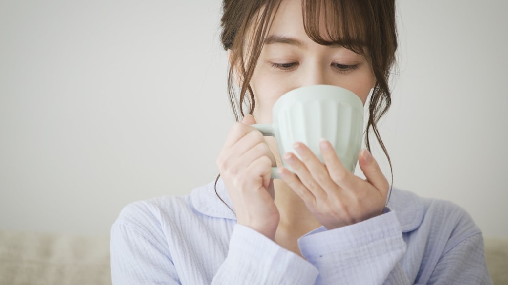 温かい飲み物を飲む女性