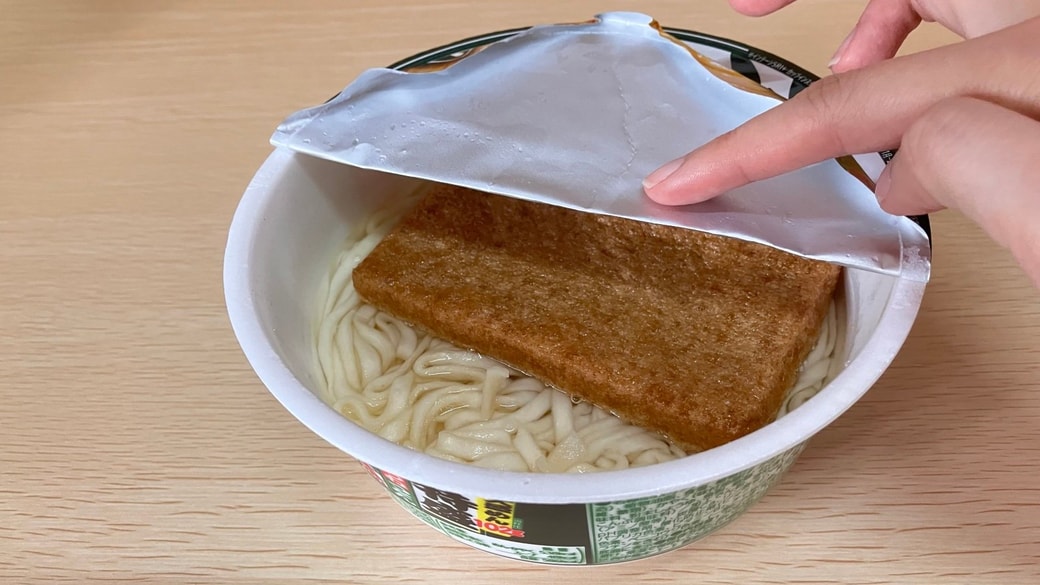 カップ麺の折り目をしっかりつける様子
