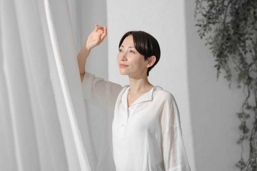 カーテンを開ける女性