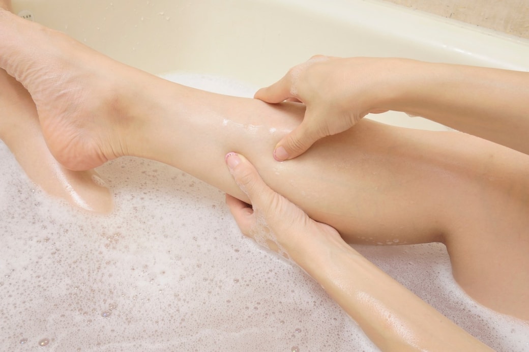 浴槽で足を揉む女性