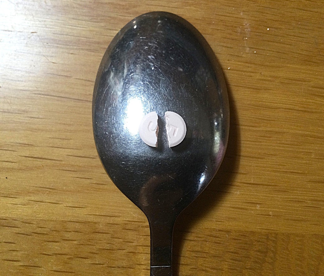 錠剤をスプーンで割る