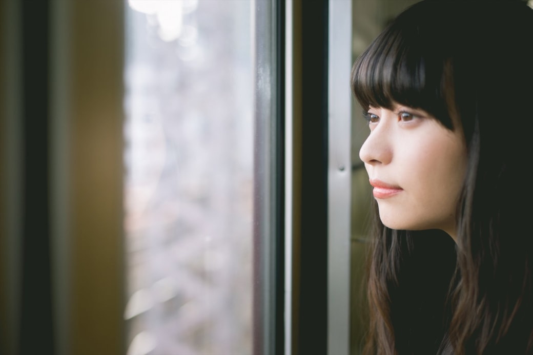 窓の外を眺める女性