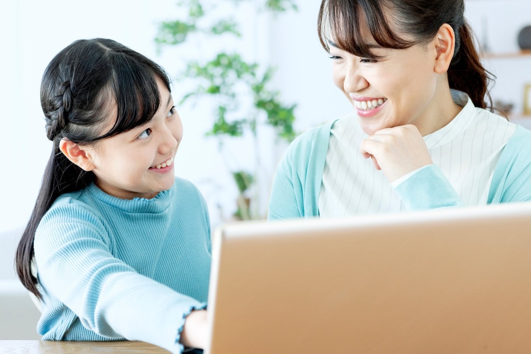 子どもと笑顔で接する女性
