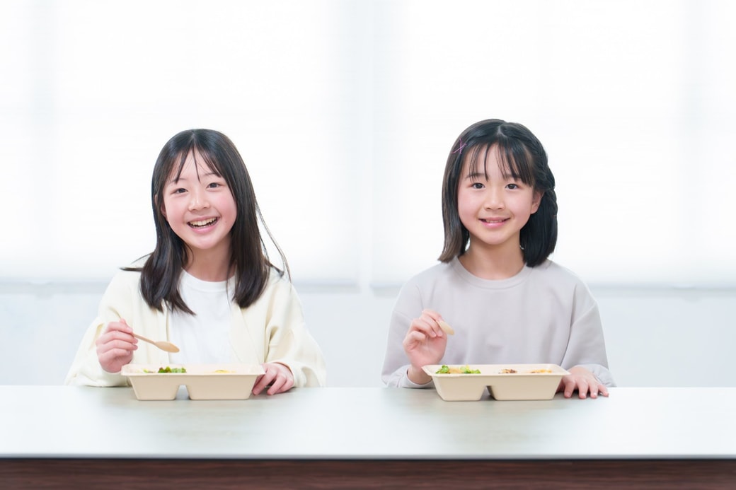 宅配弁当を食べる子