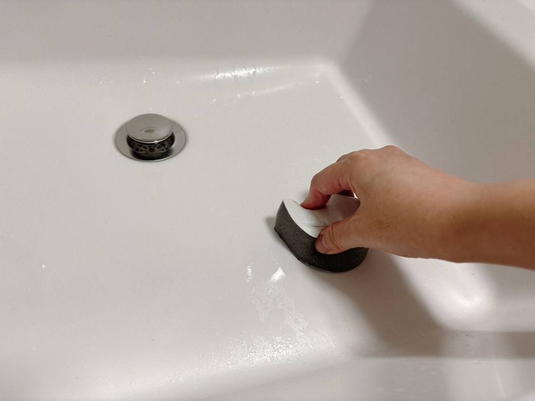 洗面ボウルをスポンジでこすり洗いする