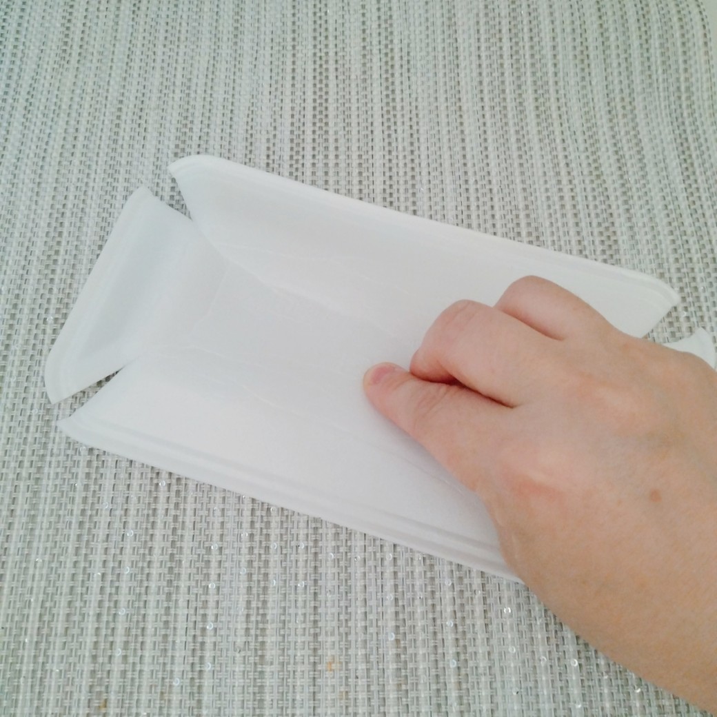 手で食品トレーを押さえる人