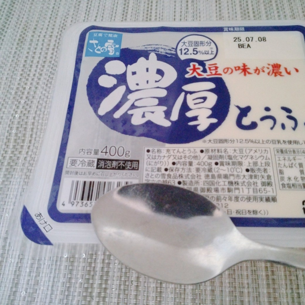 温めたスプーンで豆腐のパッケージをなぞる人