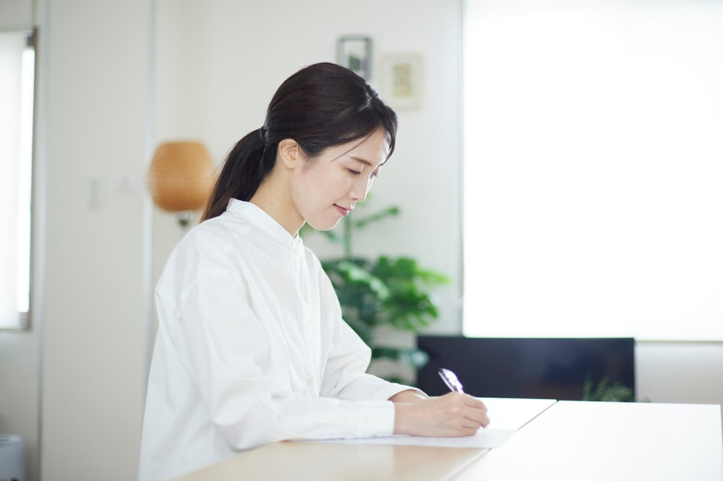 ノートを書く女性