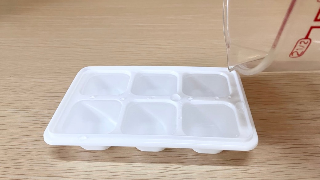 製氷皿に水をそそぐ様子