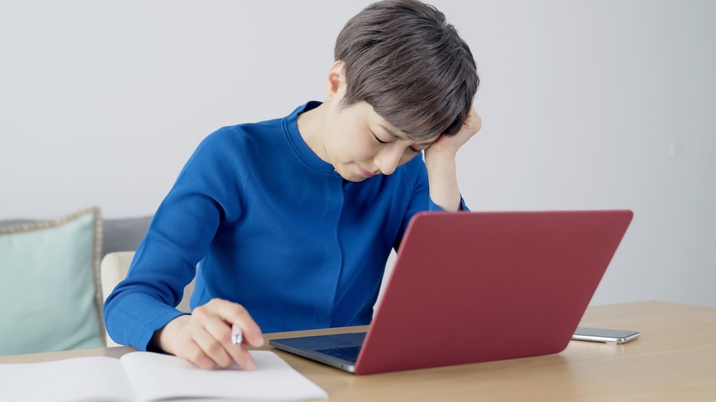 PCの前で悩む女性