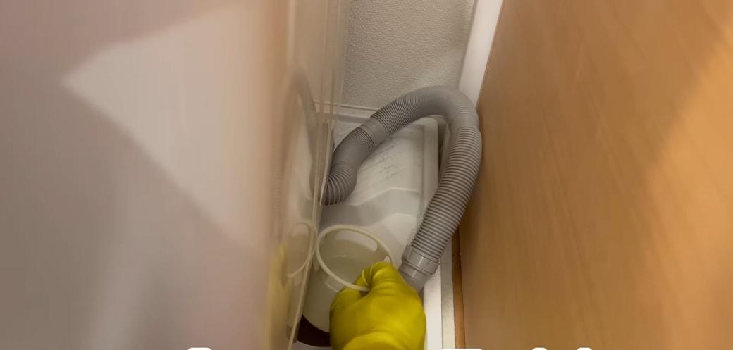 排水トラップを戻す人