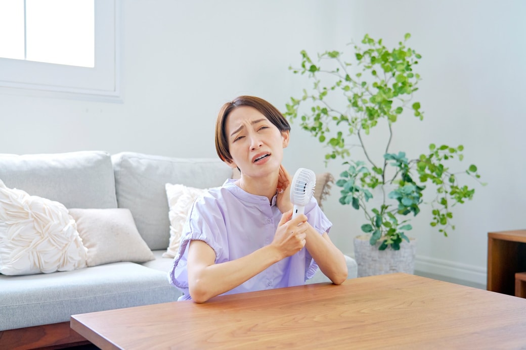 室内で暑がる女性