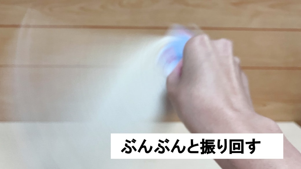 タグをつまんで振り回す様子