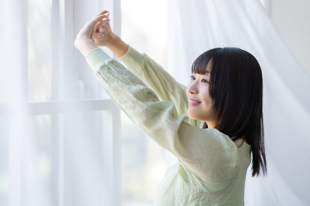 窓を開ける女性