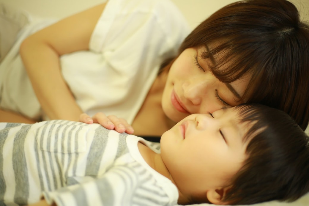 子どもと昼寝をする親子