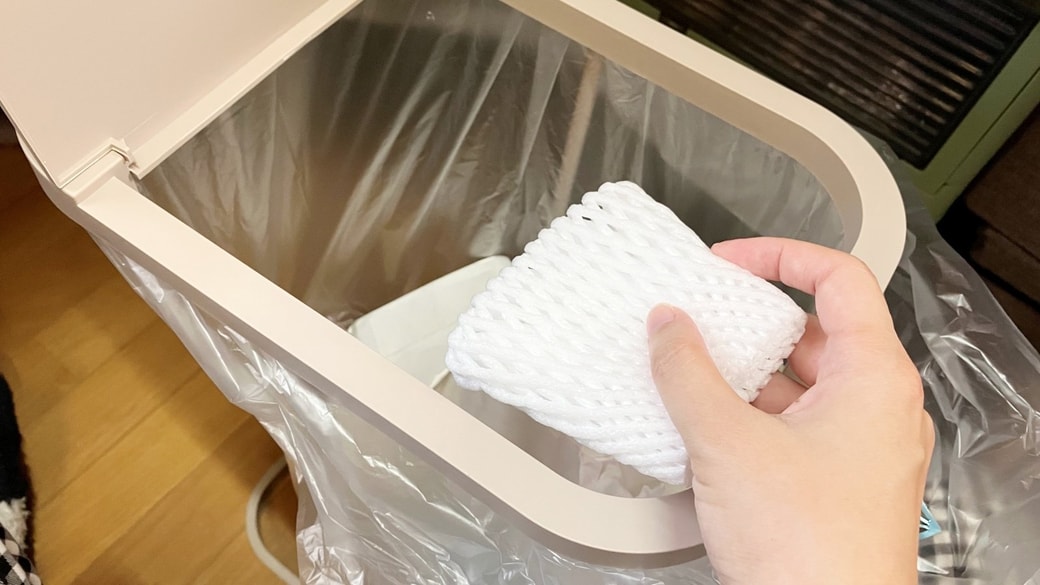 フルーツネットをゴミ箱に捨てようとしている様子