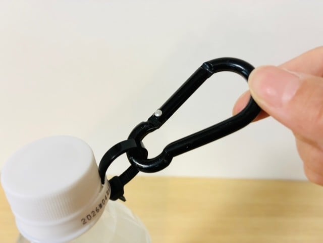 ペットボトルのフタの下にある輪っかに結束バンドとカラビナを通すだけで、持ち運びが便利になる！