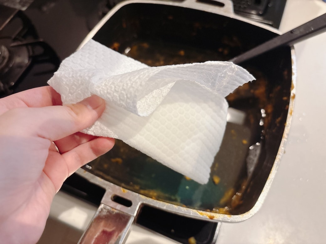 カレー鍋にキッチンペーパーを入れる