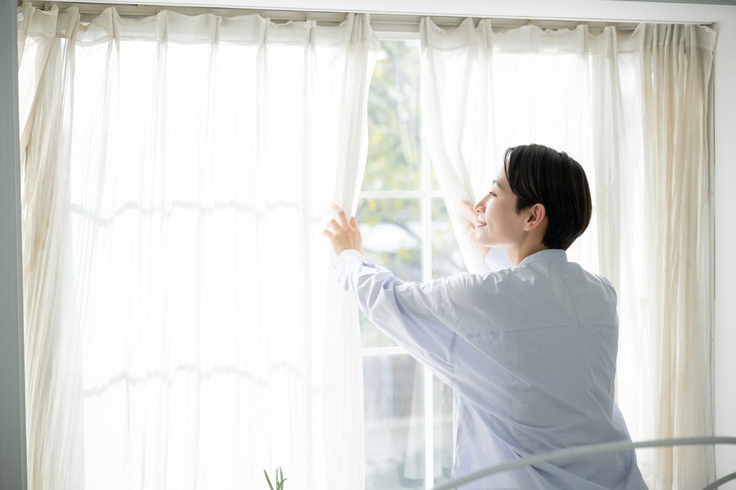 窓を開ける女性