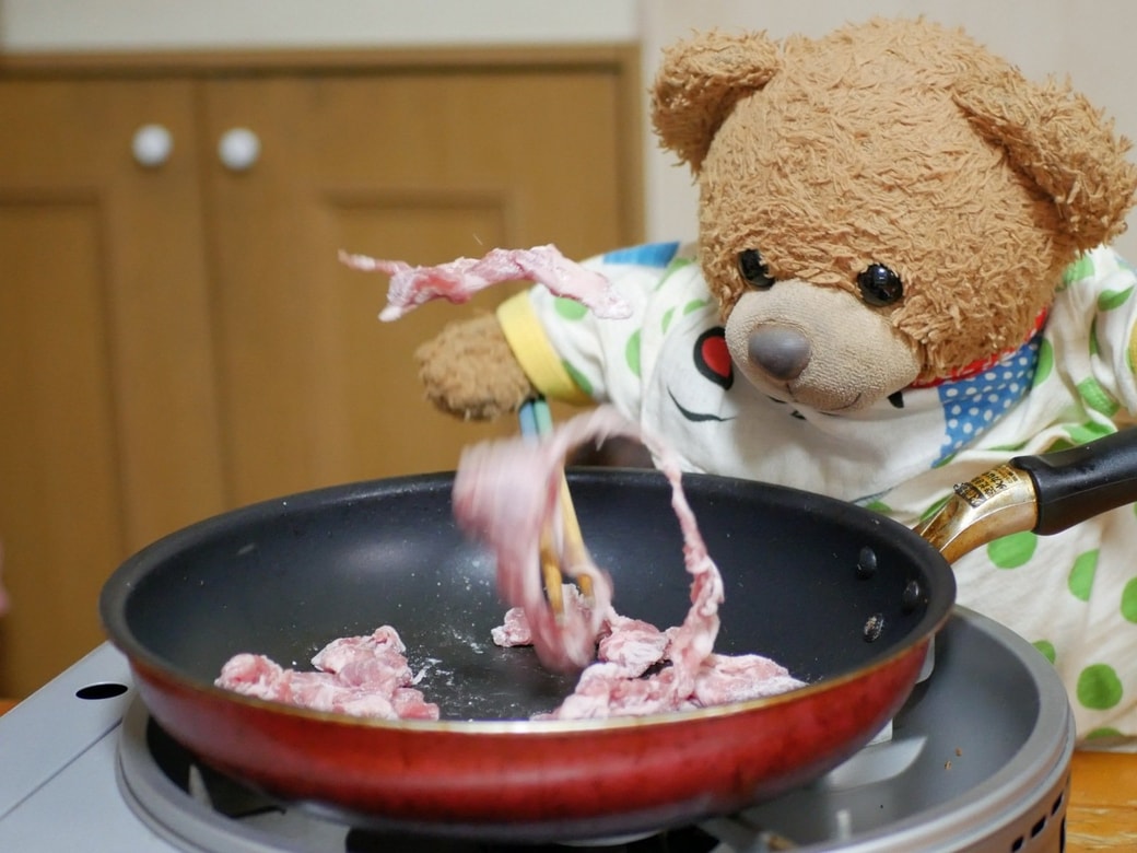 肉を炒めるくまくん