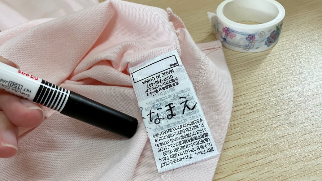 洋服のタグに巻いたマスキングテープに名前を書いた様子