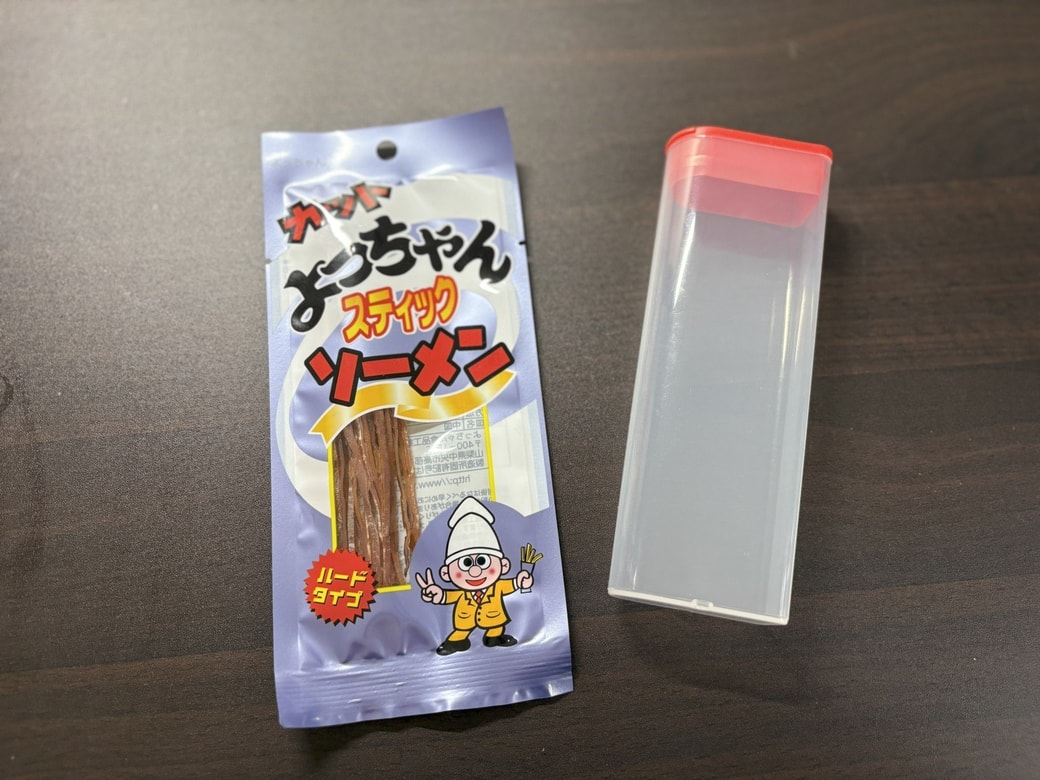 チョコベビージャンボの空き容器とよっちゃんいかそうめん