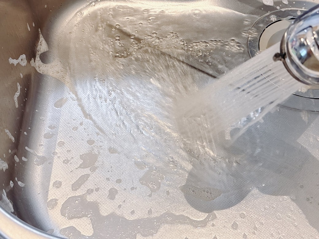 水で泡と汚れを洗い流す