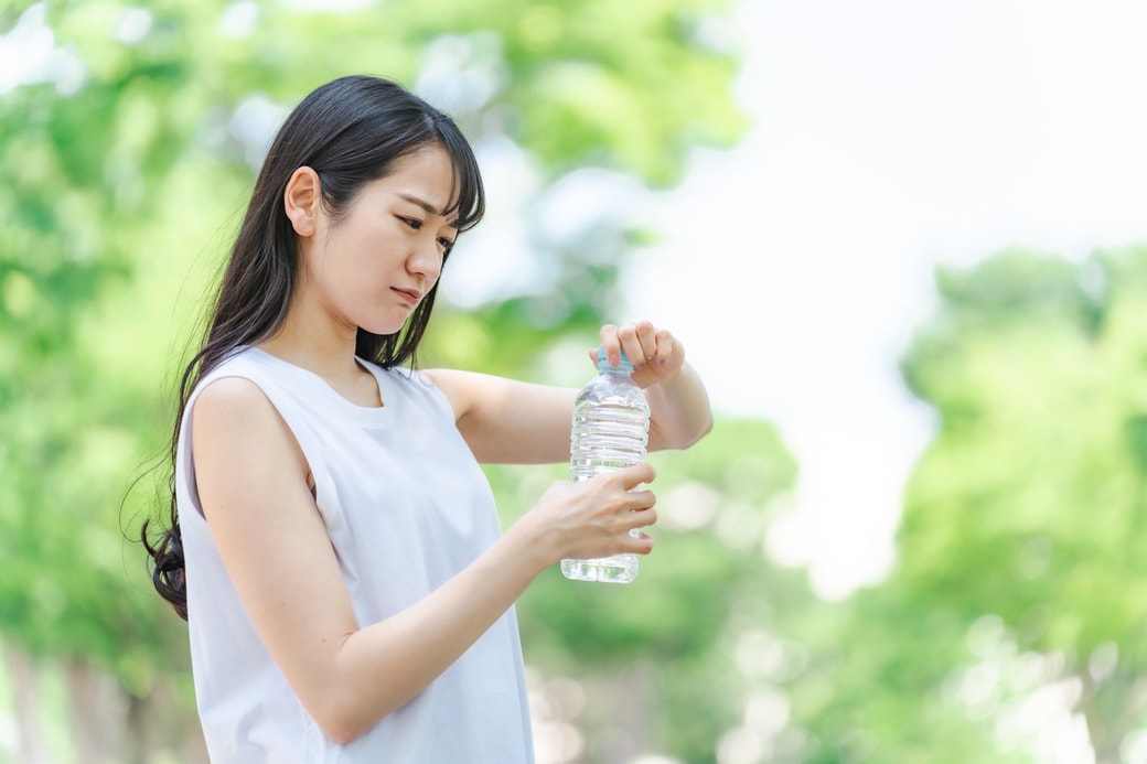 ペットボトルのふたを開ける女性