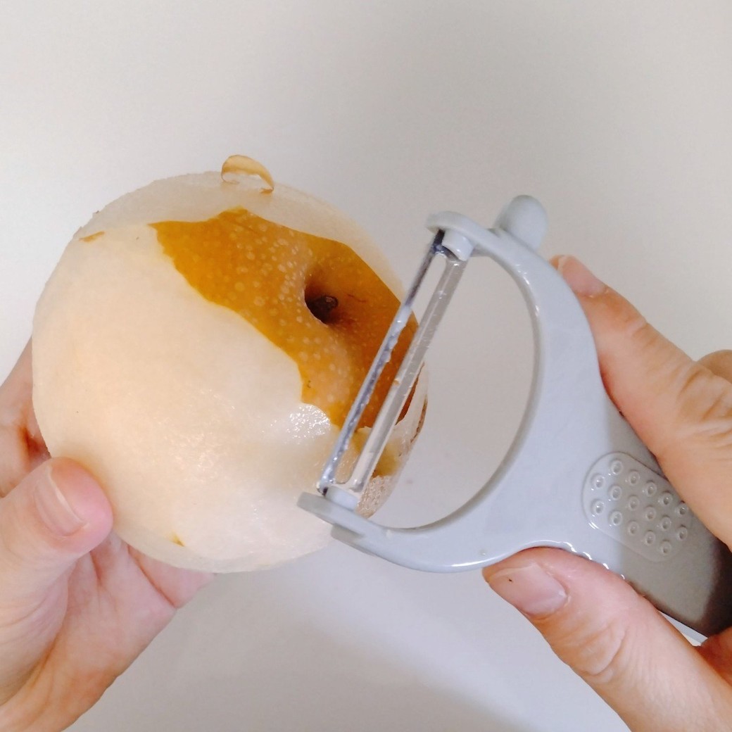 ピーラーで梨の皮を剥く人