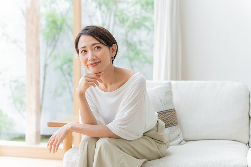 リビングで考えるミドル女性 